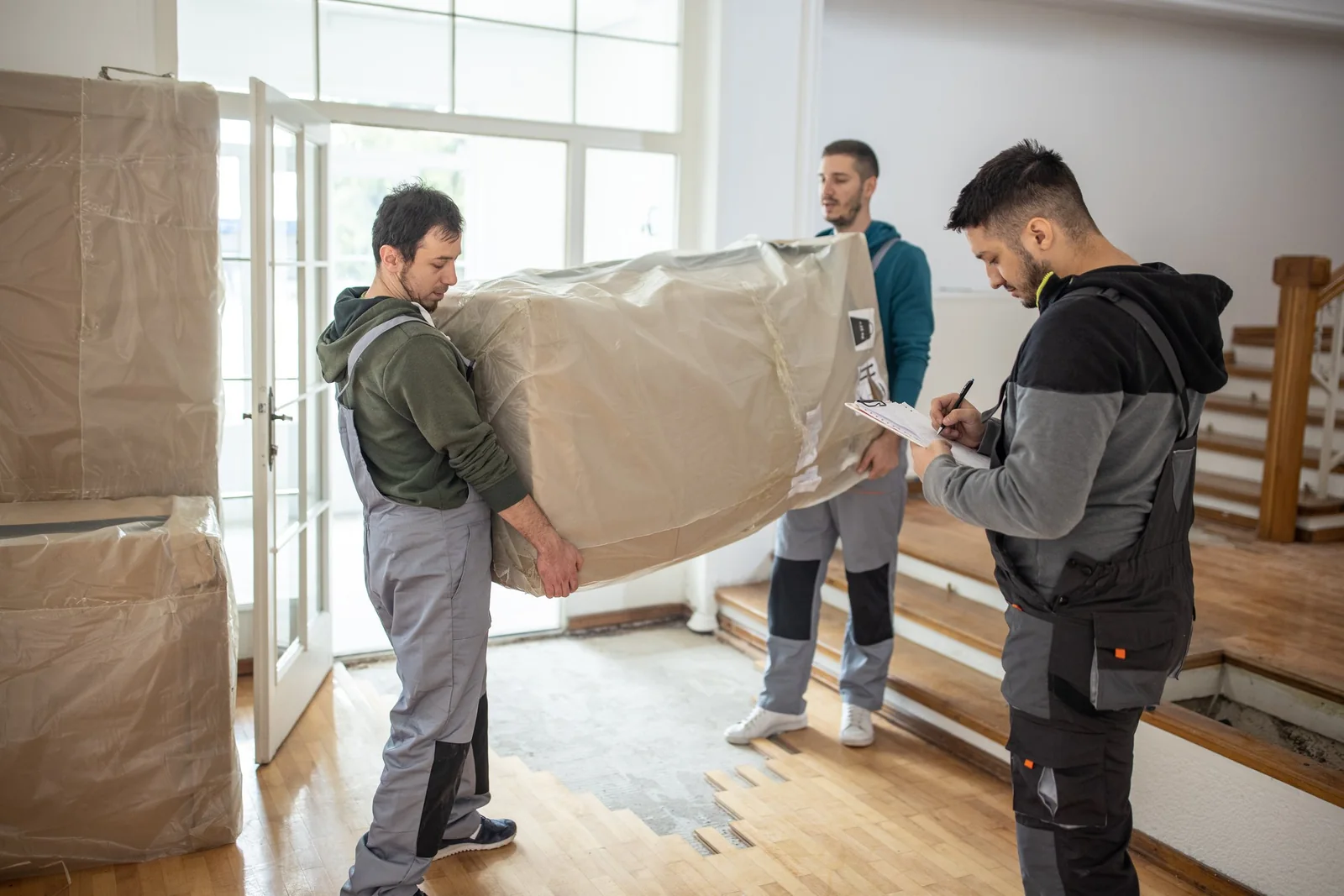 Muscle Movers Sarasota crew loading a wrapped sofa into the moving truck