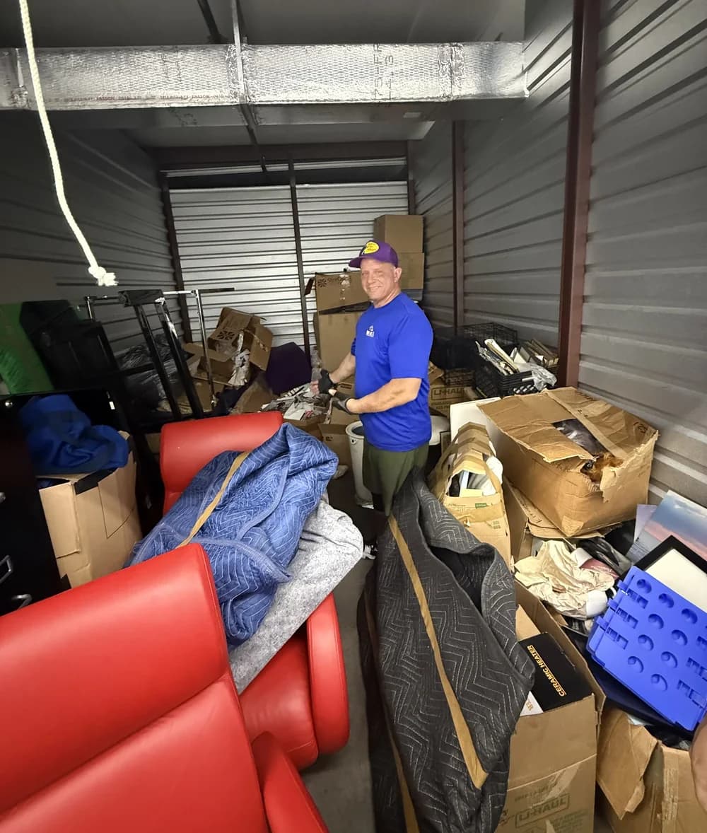Mover carrying a stack of packed and labelled moving boxes