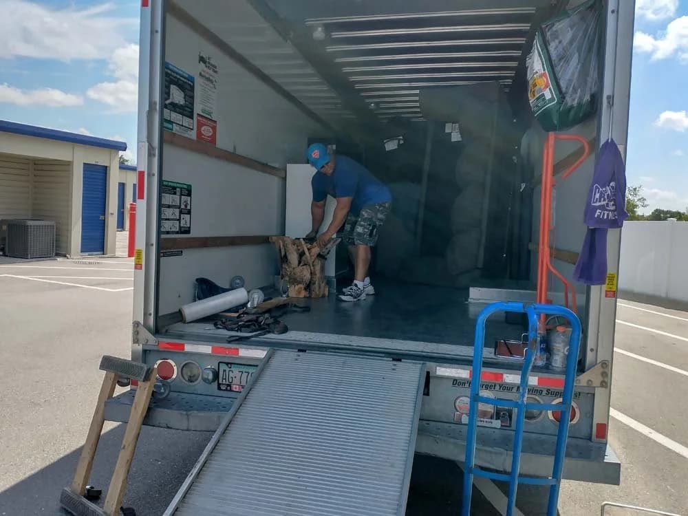 Crew carrying a wrapped furniture piece to the truck